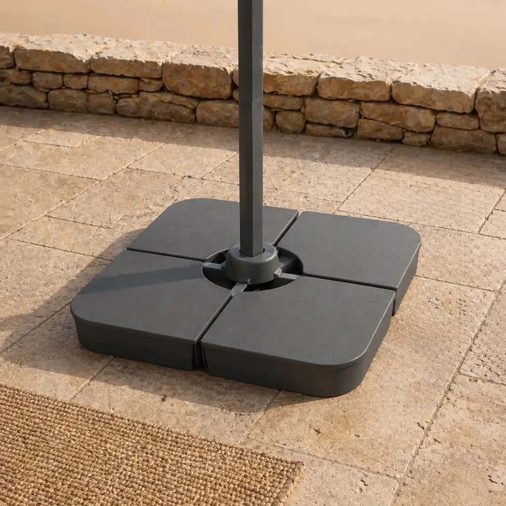 Cantilever umbrella cross base loaded with weight plates for wind stability