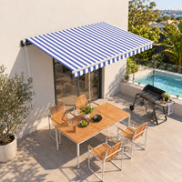 Blue and white striped automatic retractable awning shading outdoor patio dining area with pool