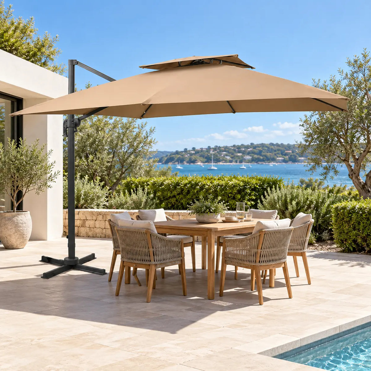 Cantilever umbrella 3x3 taupe over 6-seater teak outdoor dining set coastal Mediterranean terrace sea view pool