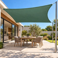 Shade sail in forest green, a rectangle sail over a garden patio table, blending with the plants