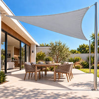 Shade sail in light grey, a triangle stretched between the roof and a steel post over a patio table