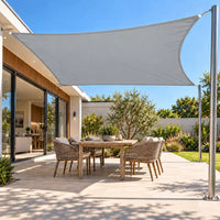 Shade sail in light grey, a waterproof rectangle stretched between the house and a steel post over a patio table