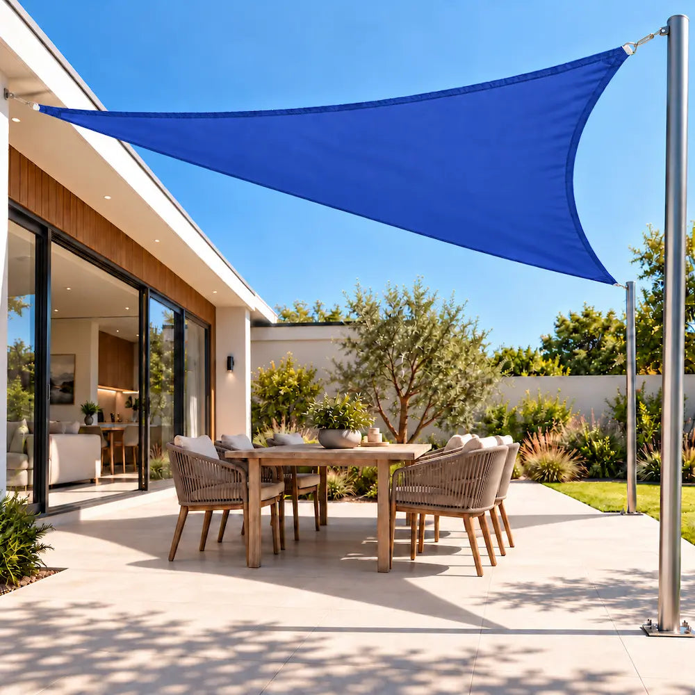 Shade sail in ocean blue, a waterproof triangle shading an outdoor dining setting on a patio