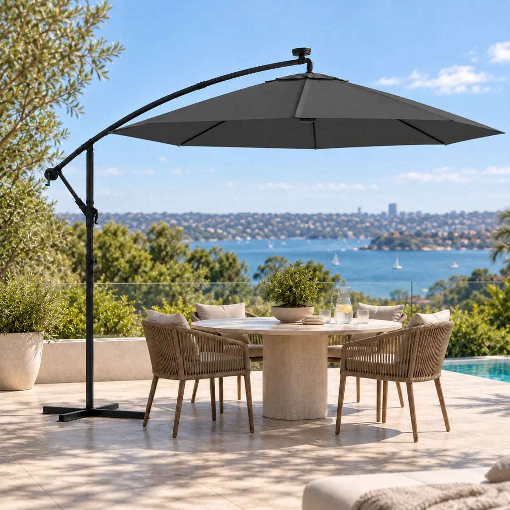 Round cantilever umbrella 3m anthracite solar LED over 5-seater round marble outdoor dining table poolside Sydney harbour view terrace