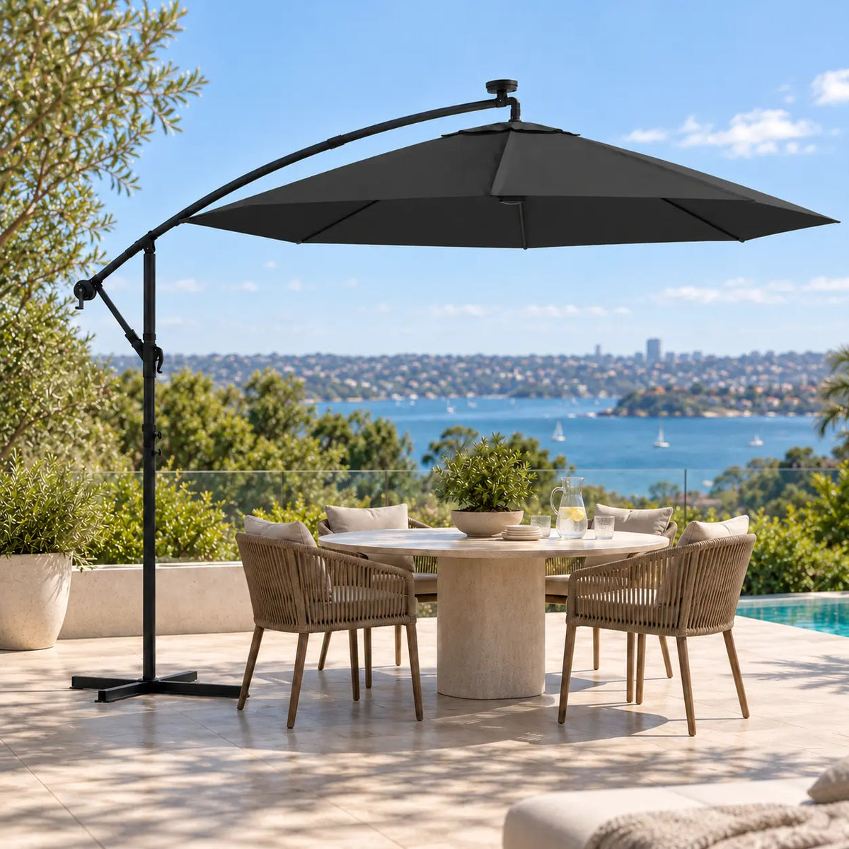 Round cantilever umbrella 3m black solar LED over 5-seater round marble outdoor dining table poolside Sydney harbour view terrace
