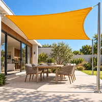 Shade sail in sunflower yellow, a bright rectangle over a backyard patio dining table