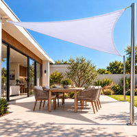 Shade sail in white, a bright triangular canopy over an outdoor dining area of a modern home