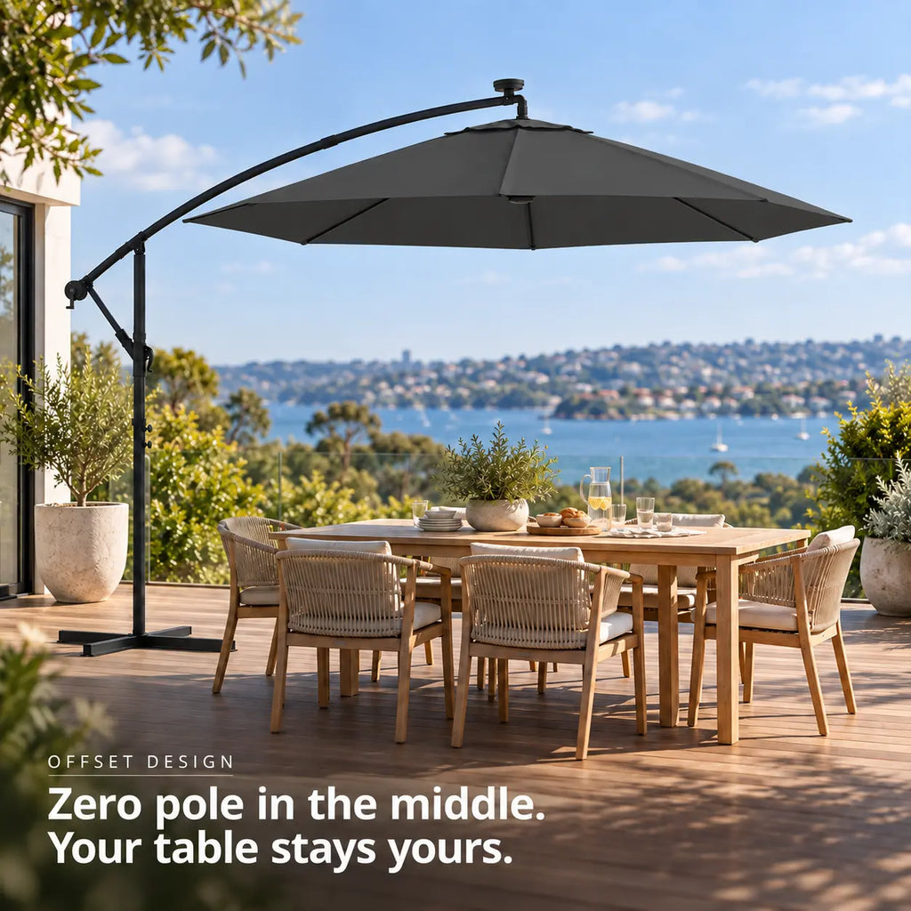 Round cantilever umbrella 3m anthracite solar LED offset design no centre pole 6-seater teak dining table wooden deck coastal sea view