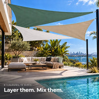 Shade sail layered in forest green, white and sand, triangular sails over a tropical pool lounge