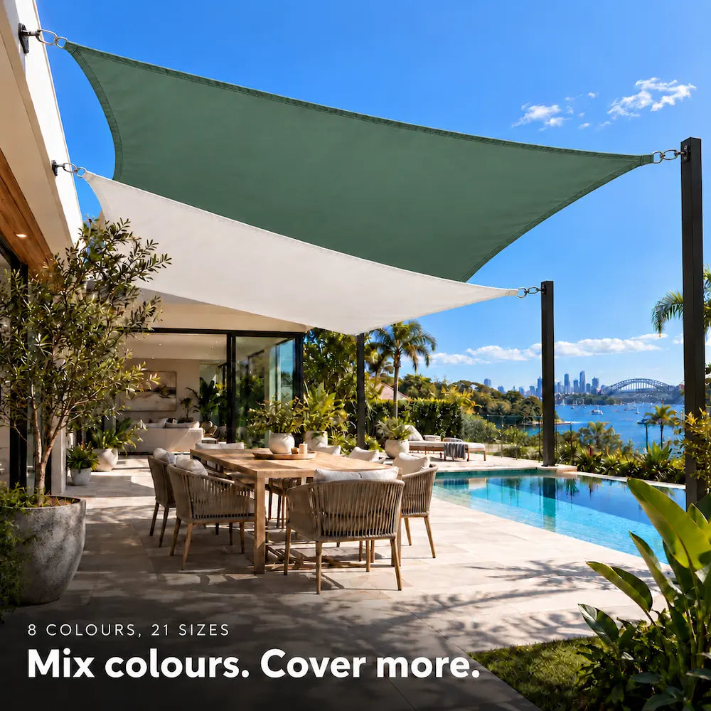 Shade sail pairing of forest green and white rectangles over a tropical poolside dining area