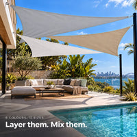 Shade sail group in light grey, white and sand, overlapping triangles above a poolside lounge