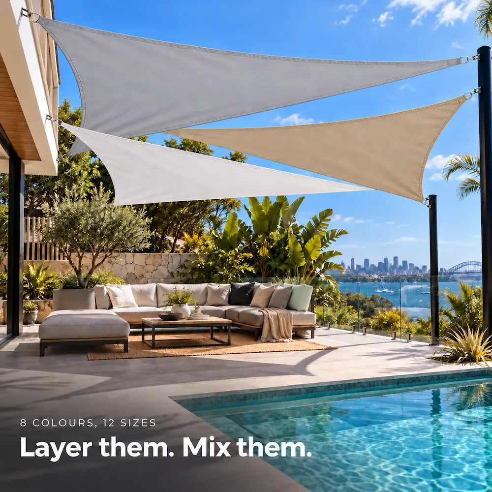 Shade sail group in light grey, white and sand, overlapping triangles above a poolside lounge