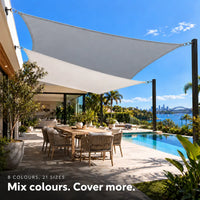 Shade sail set in light grey and white, two rectangular sails over a dining area beside an infinity pool