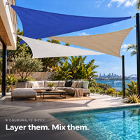 Shade sail design in ocean blue, white and sand triangles over a poolside sofa with harbour views