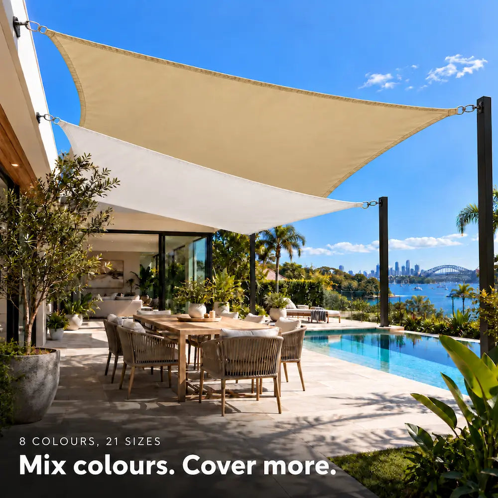 Shade sail duo in sand and white, rectangles layered above a pool terrace overlooking the harbour