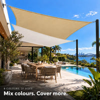 Shade sail duo in sand and white, rectangles layered above a pool terrace overlooking the harbour