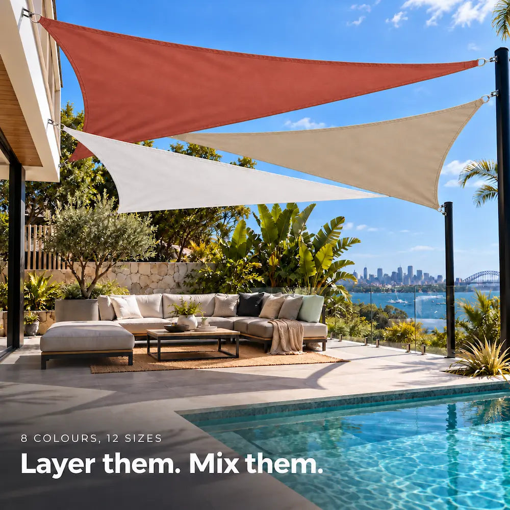 Shade sail blend of terracotta, white and sand, layered triangles over an outdoor lounge by the pool