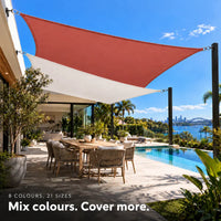 Shade sail mix of terracotta and white rectangles over a pool terrace with a waterfront view