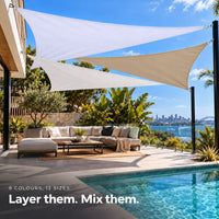 Shade sail arrangement of white and sand triangles over a pool deck with city views