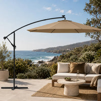 Round cantilever umbrella 3m Taupe over outdoor lounge set on open sea-view patio with jute rug – Meltem
