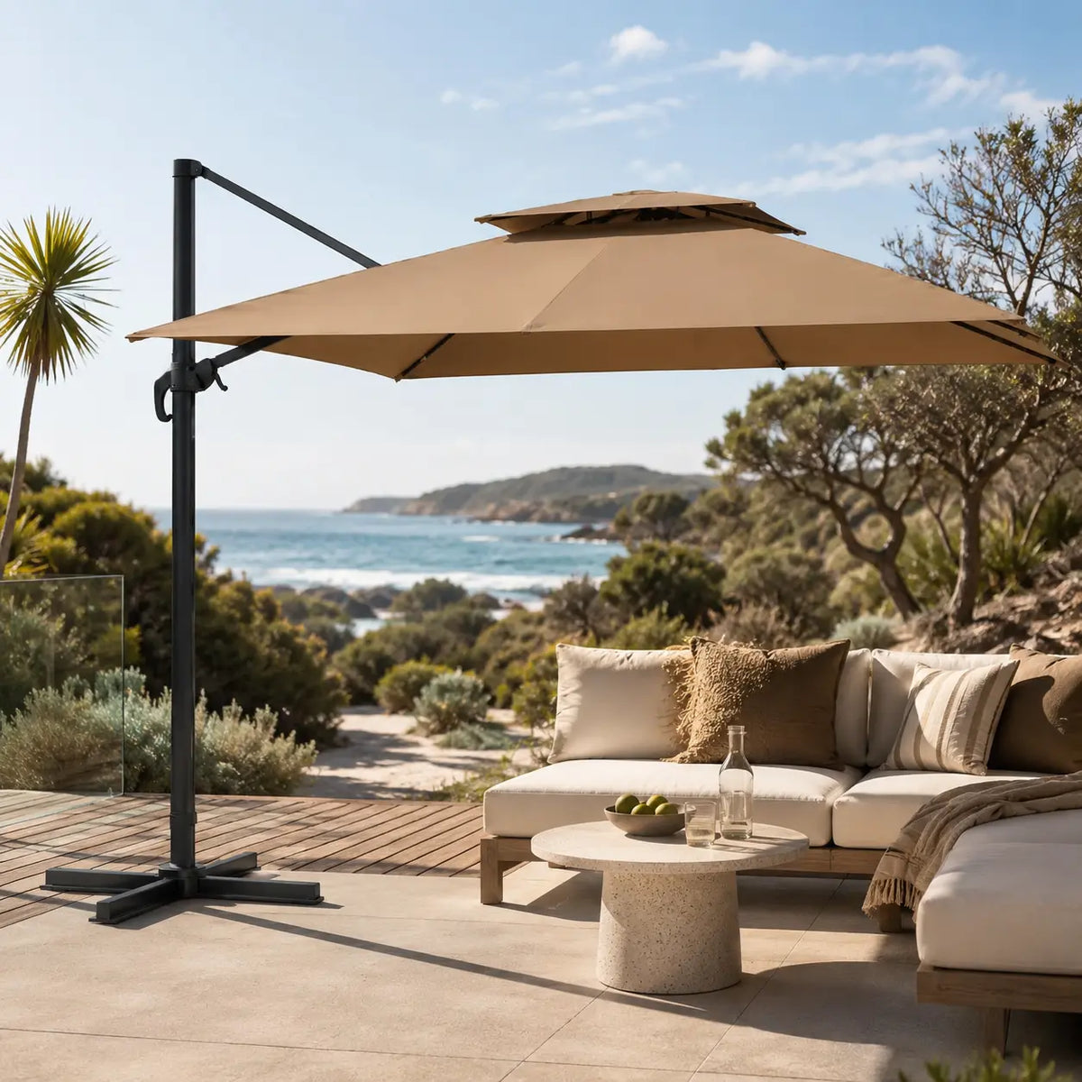 Taupe cantilever umbrella providing shade over an outdoor sofa on a beachside patio in full sun