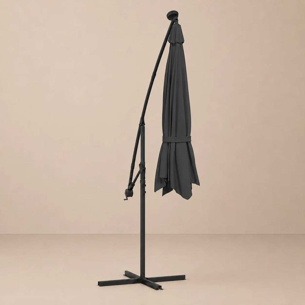 Round cantilever umbrella 3m Black folded and secured with carry strap on cross stand with solar panel – Maestro