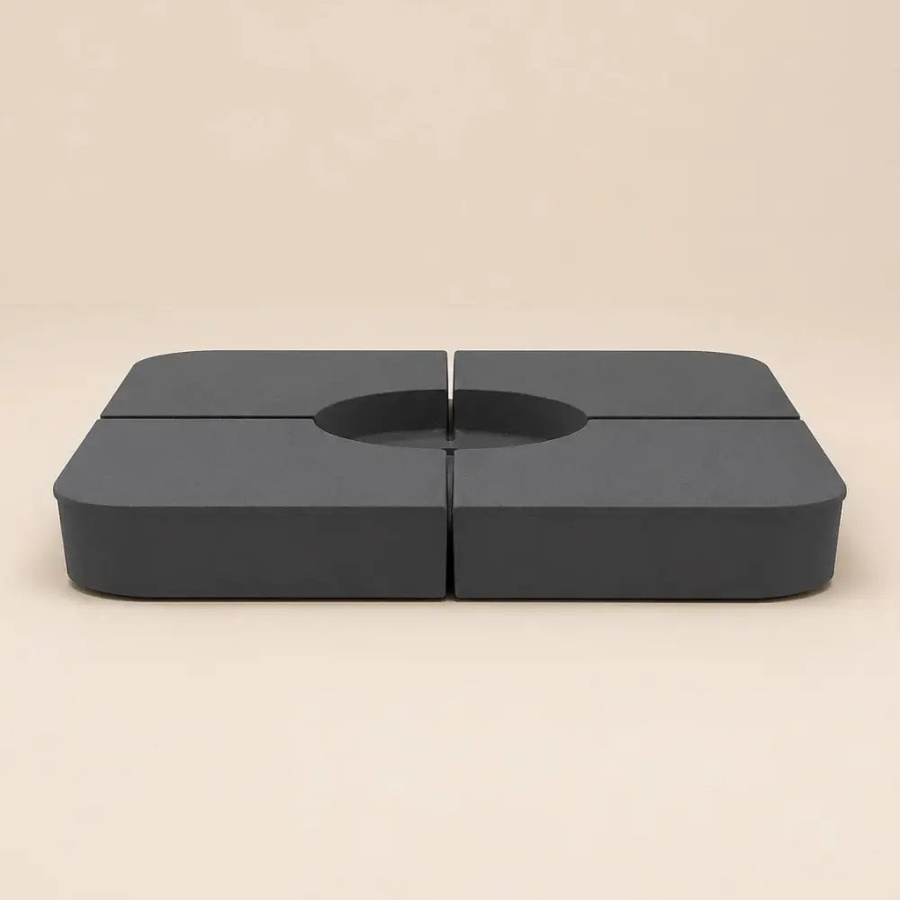Two of the four anthracite sand-fill plates shown assembled around a cross-base opening, Holdfast fillable ballast kit