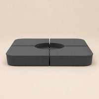 Two of the four anthracite sand-fill plates shown assembled around a cross-base opening, Holdfast fillable ballast kit