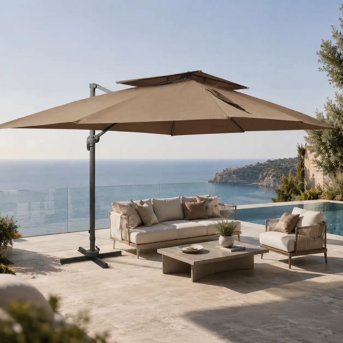 Rectangular taupe cantilever umbrella 3x4m with vented double canopy shading a poolside lounge on a coastal terrace