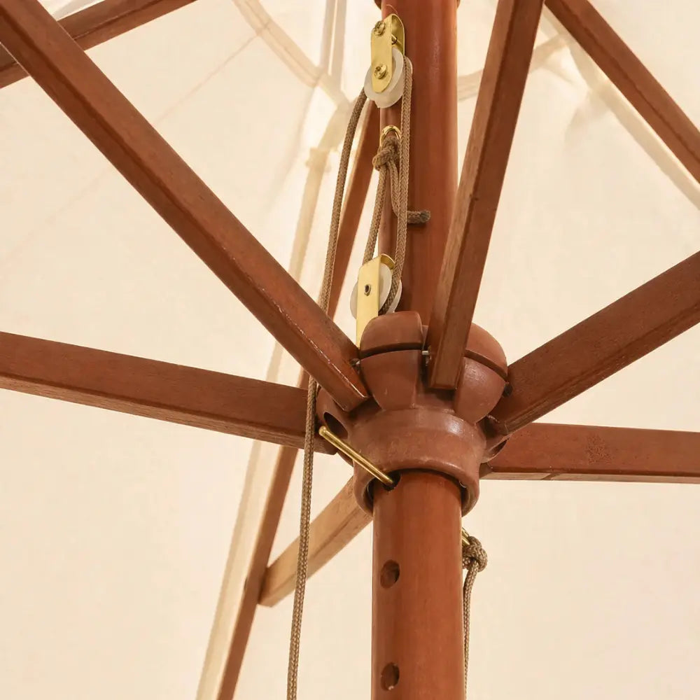 Close-up of the hardwood hub and brass pulley rope mechanism on the Mas 3m round market umbrella