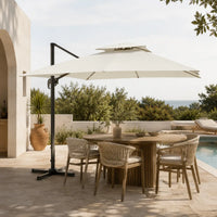 Ivory cantilever umbrella 3x3m with vented double canopy shading an outdoor dining table on a poolside terrace