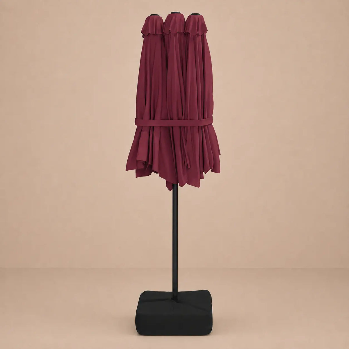 Bordeaux double canopy market umbrella folded closed on black aluminium pole with square weighted base