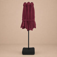 Bordeaux double canopy market umbrella folded closed on black aluminium pole with square weighted base