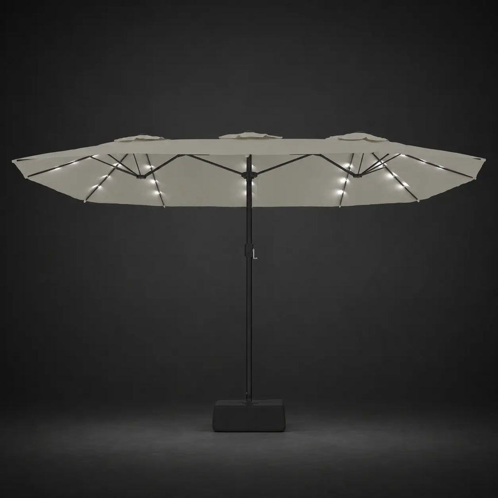 Sand white double canopy market umbrella with integrated LED lights illuminated at night on a dark background