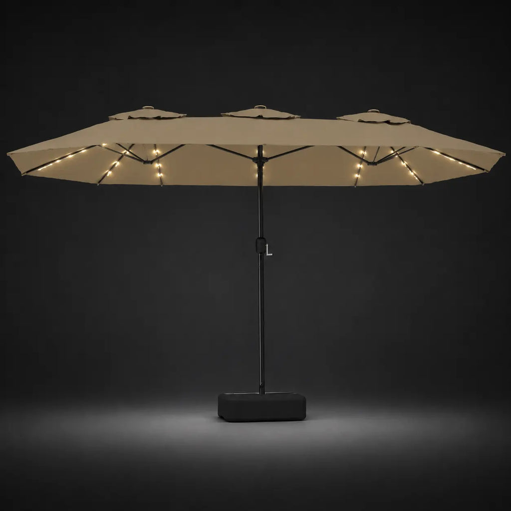 Taupe double canopy market umbrella with integrated LED lights illuminated at night on a dark background