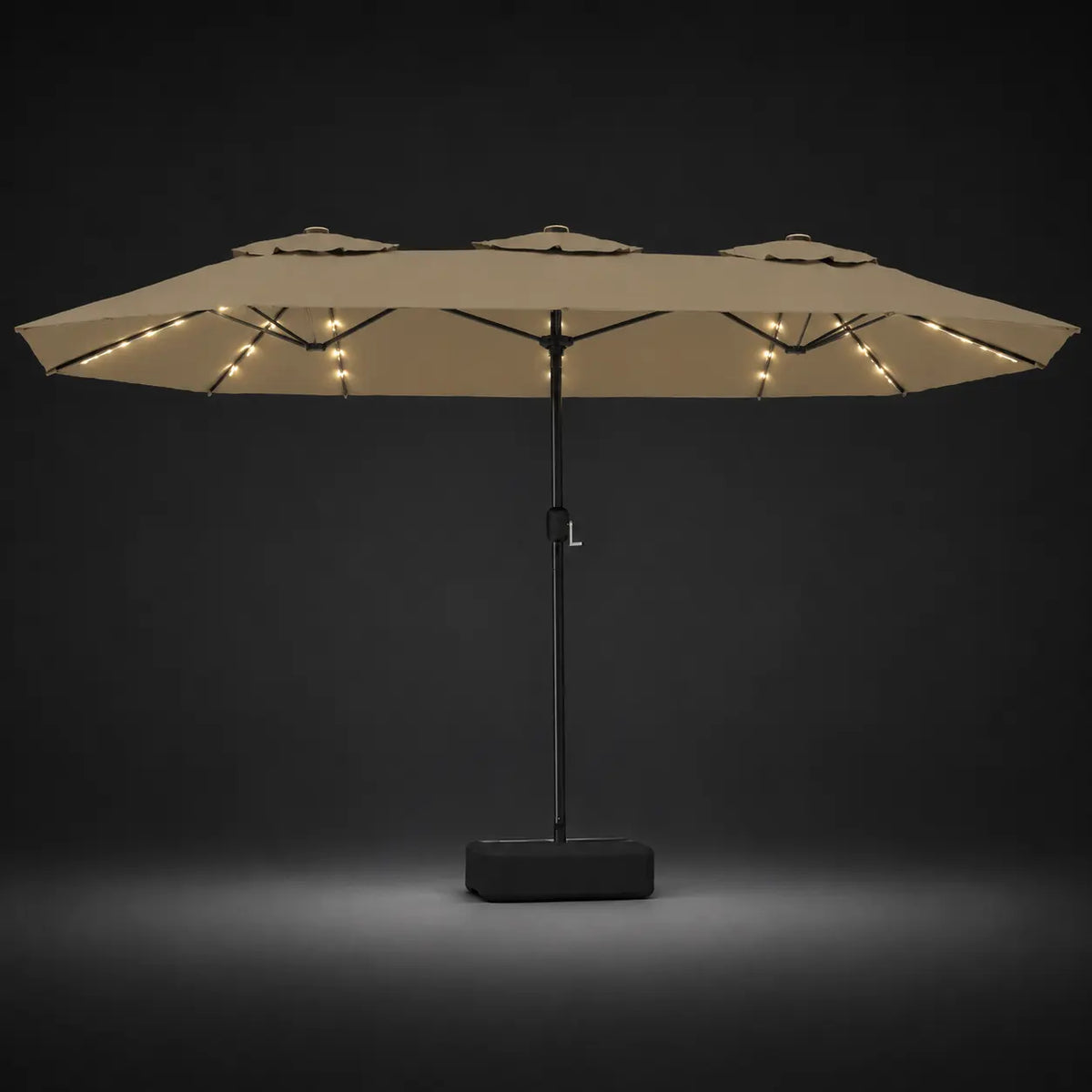 Taupe double canopy market umbrella with integrated LED lights illuminated at night on a dark background