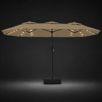 Taupe double canopy market umbrella with integrated LED lights illuminated at night on a dark background