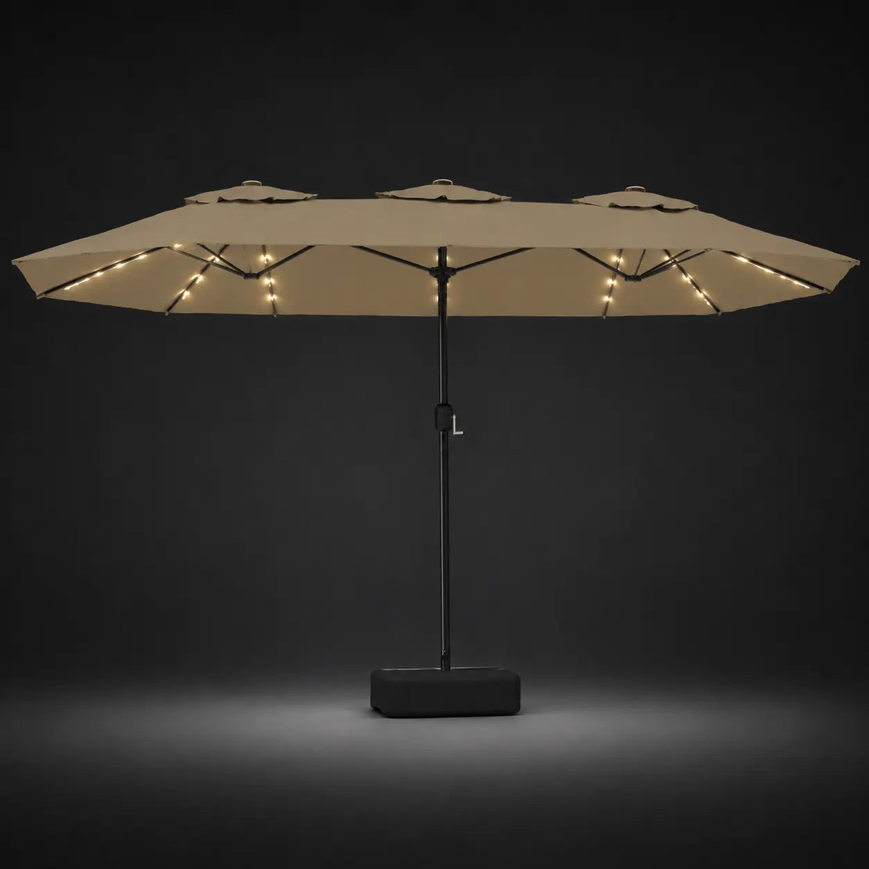 Taupe double canopy market umbrella with integrated LED lights illuminated at night on a dark background