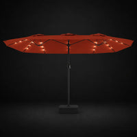 Terracotta double canopy market umbrella with integrated LED lights illuminated at night on a dark background