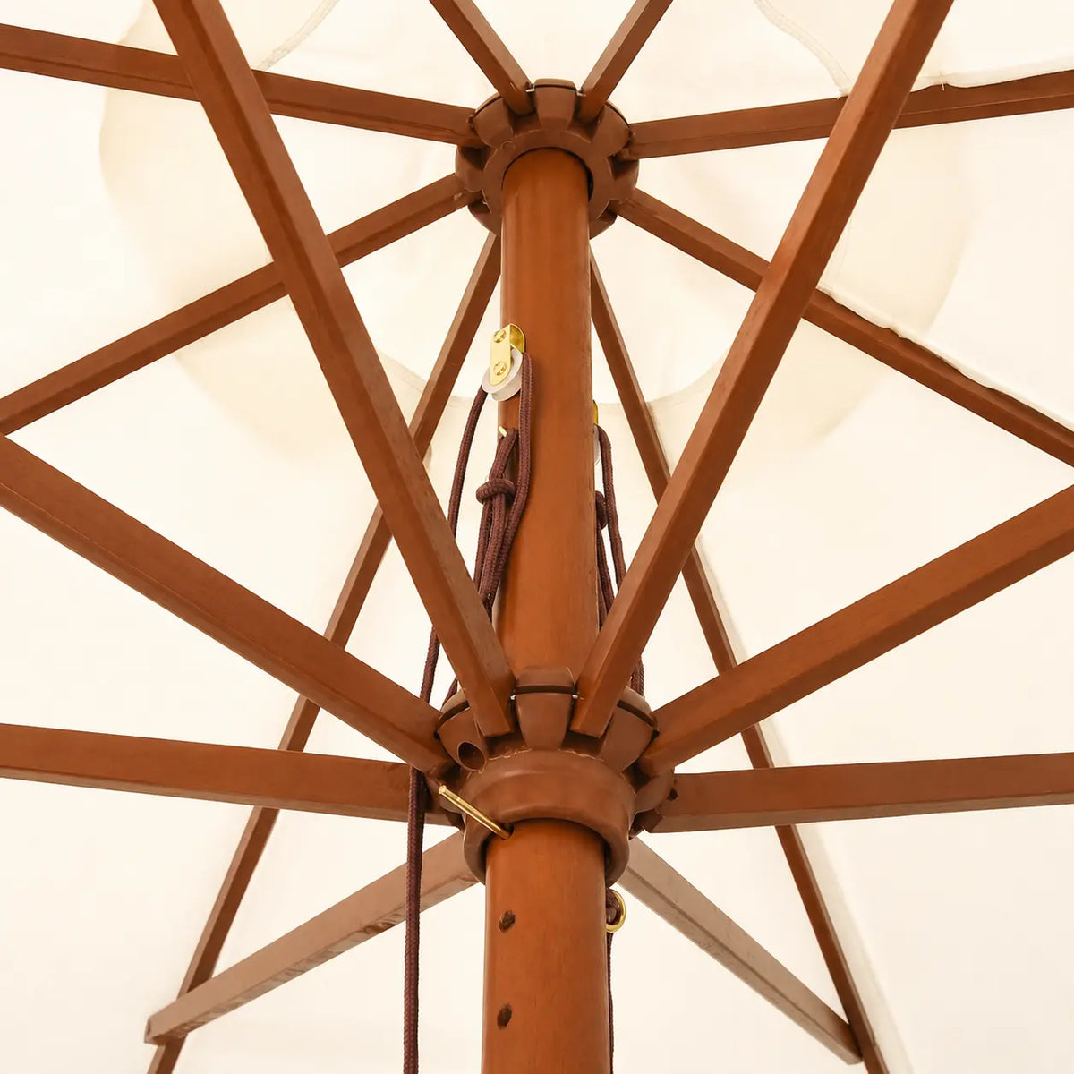 Underside view of a market umbrella showing hardwood rib frame, double pulley rope mechanism and brass fittings