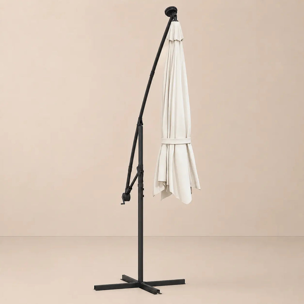 Round cantilever umbrella 3m Sand folded and secured with carry strap on cross stand with solar panel – Solano