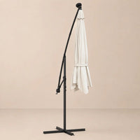 Round cantilever umbrella 3m Sand folded and secured with carry strap on cross stand with solar panel – Solano