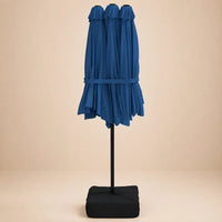 Azure blue double canopy market umbrella folded closed on black aluminium pole with square weighted base