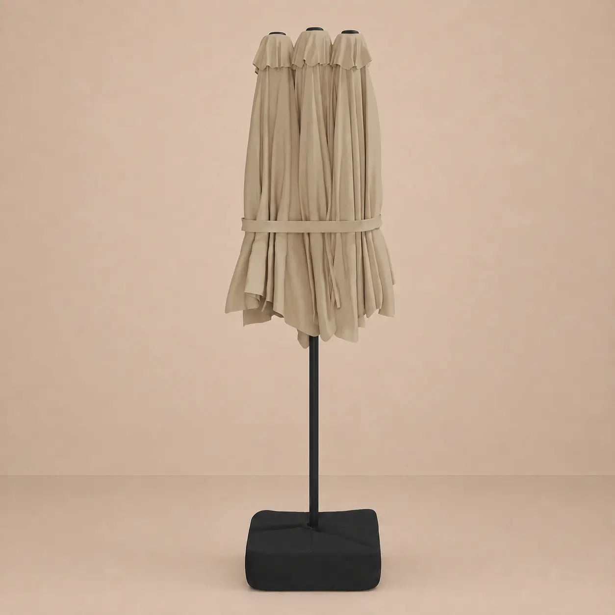 Taupe double canopy market umbrella folded closed on black aluminium pole with square weighted base