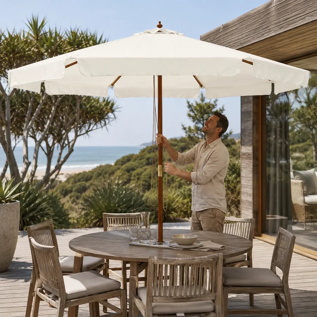 3.3m sand white market umbrella set up over a round outdoor dining table on a coastal Australian deck