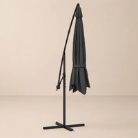 Round cantilever umbrella 3.5m Black folded and secured with carry strap on cross stand – Ostro