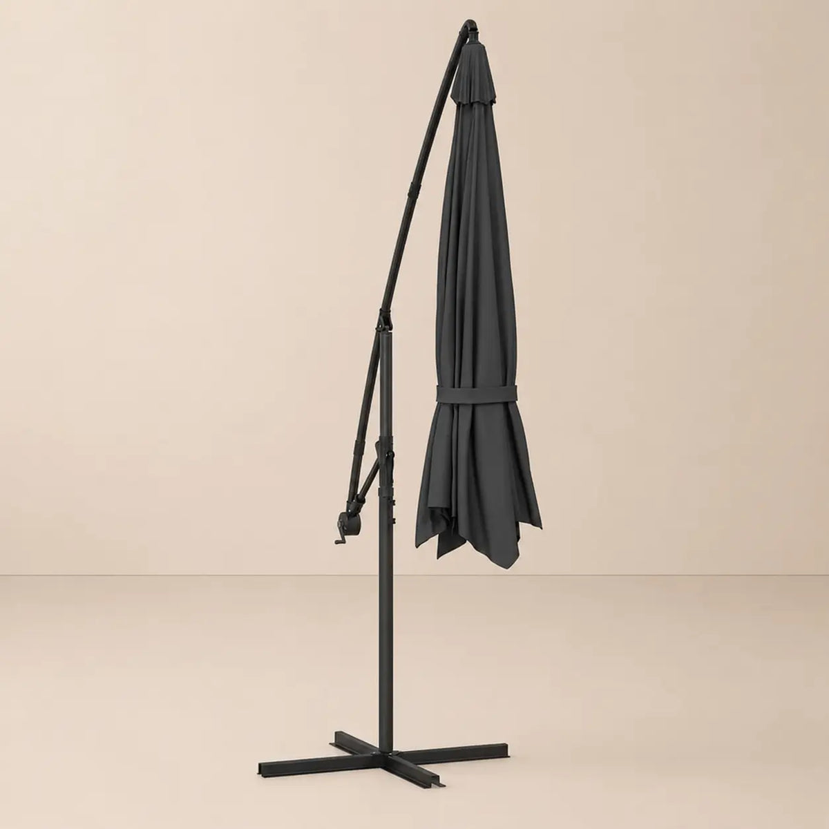 Round cantilever umbrella 3.5m Black folded and secured with carry strap on cross stand – Ostro