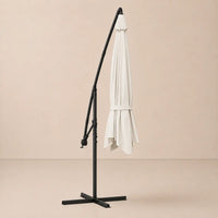 Round cantilever umbrella 3.5m Sand White folded and secured with carry strap on cross stand – Zephyr