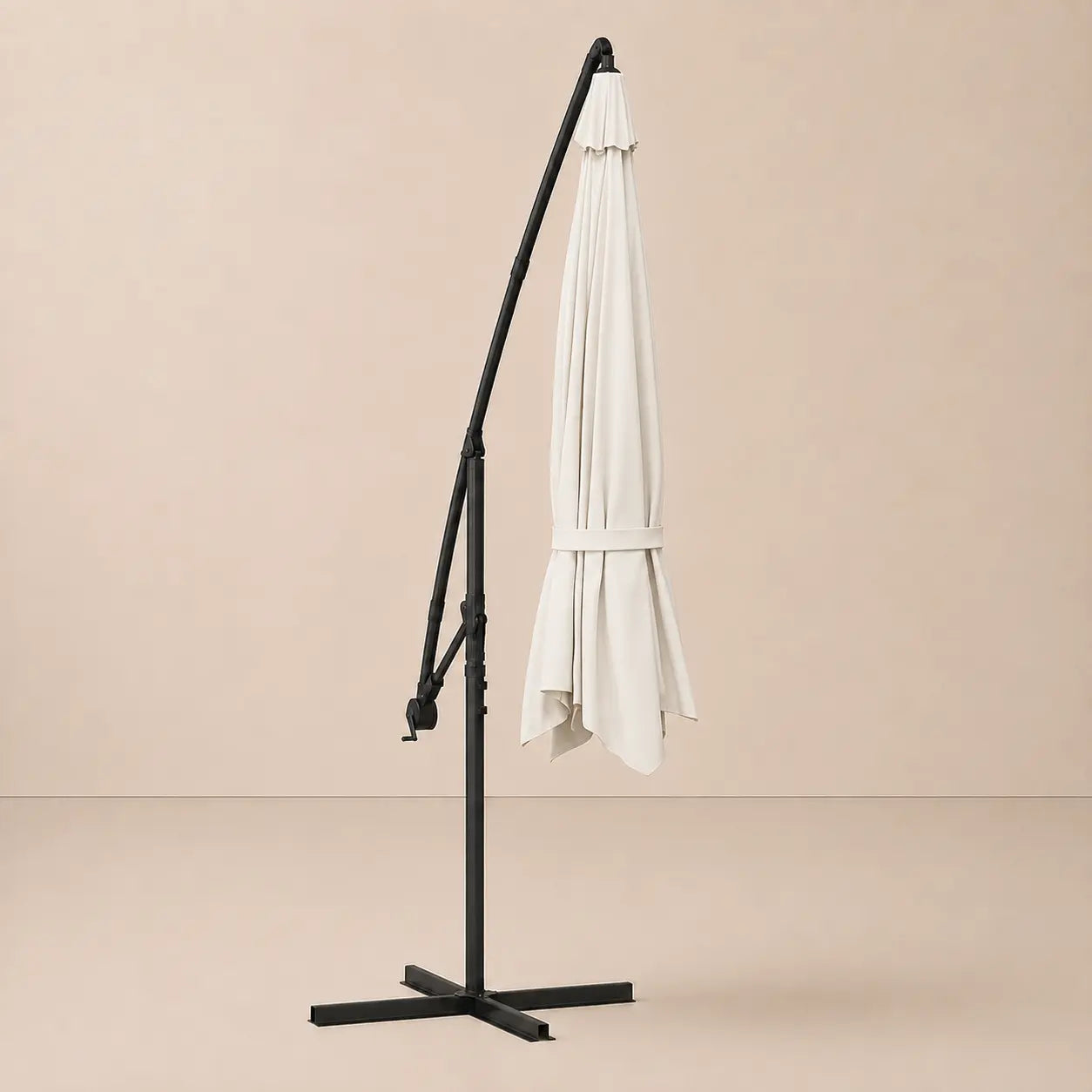Round cantilever umbrella 3.5m Sand White folded and secured with carry strap on cross stand – Zephyr