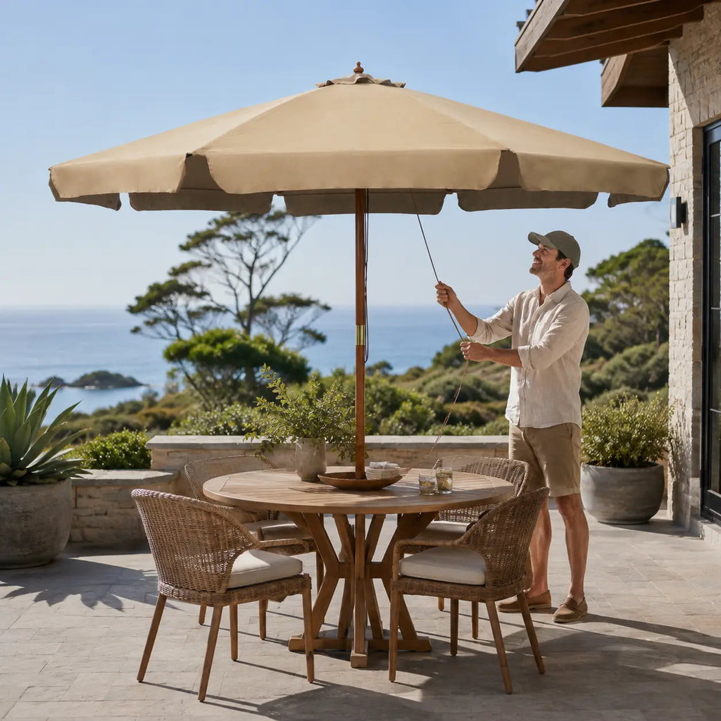 Taupe market umbrella set up over a round outdoor dining table on a coastal Australian deck